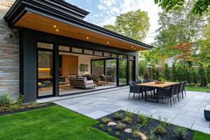 Modern open concept home backyard patio with dining table and chairs in summer photo