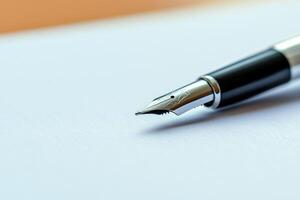 Elegant golden fountain pen lying on a white sheet of paper photo