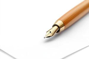 Elegant golden fountain pen lying on a white sheet of paper photo