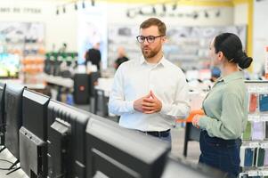 Portrait of a Female Customer Seeking Advice from Retail Home Electronics Expert photo