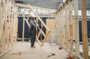 Process of construction new and modern modular house. Worker man in special protective uniform wear working on building development industry of energy efficient property photo