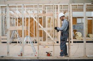 Process of construction new and modern modular house. Worker man in special protective uniform wear working on building development industry of energy efficient property photo
