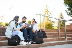 group of young students checking exam results or waiting for project approval on laptop at collage campus photo