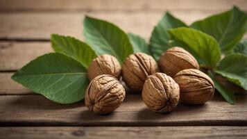 ripe and youthful walnuts with their green leaves on a wooden surface. photo
