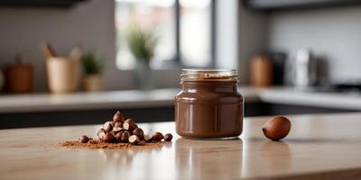 Chocolate hazelnut spread in a glass jar on a kitchen counter. photo