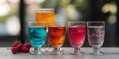 Three glasses with different colored drinks on a table. photo