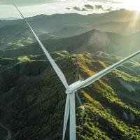 close up of a white wind turbine against the backdrop of a lush green forest and mountains photo