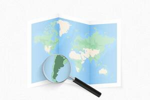Enlarge Argentina with a magnifying glass on a folded map of the world. vector