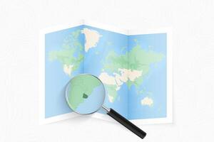 Enlarge Uruguay with a magnifying glass on a folded map of the world. vector