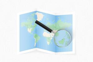 Enlarge Brunei with a magnifying glass on a folded map of the world. vector