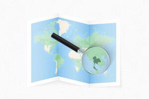 Enlarge Thailand with a magnifying glass on a folded map of the world. vector