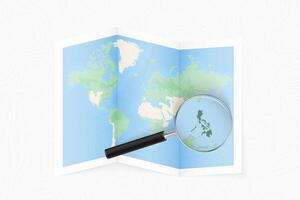 Enlarge Philippines with a magnifying glass on a folded map of the world. vector