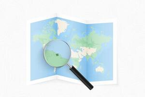 Enlarge Suriname with a magnifying glass on a folded map of the world. vector