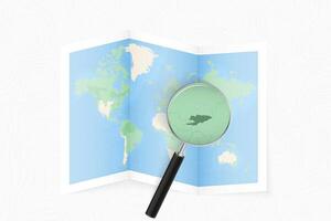 Enlarge Kyrgyzstan with a magnifying glass on a folded map of the world. vector