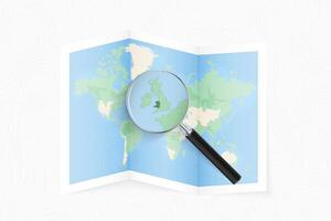Enlarge Wales with a magnifying glass on a folded map of the world. vector