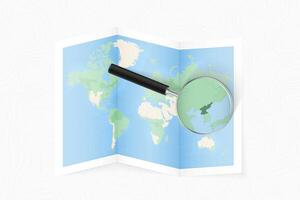 Enlarge North Korea with a magnifying glass on a folded map of the world. vector