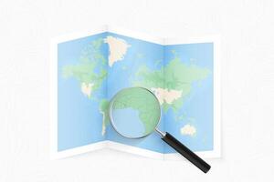 Enlarge Sao Tome and Principe with a magnifying glass on a folded map of the world. vector