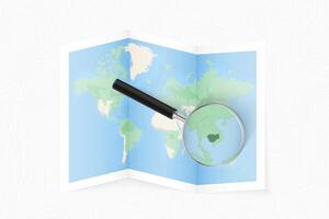 Enlarge Cambodia with a magnifying glass on a folded map of the world. vector
