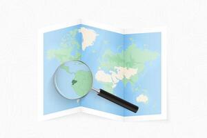 Enlarge Ecuador with a magnifying glass on a folded map of the world. vector