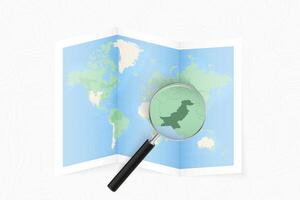 Enlarge Pakistan with a magnifying glass on a folded map of the world. vector