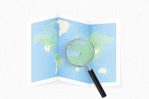 Enlarge Lebanon with a magnifying glass on a folded map of the world. vector