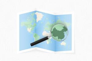 Enlarge China with a magnifying glass on a folded map of the world. vector