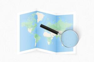 Enlarge Kiribati with a magnifying glass on a folded map of the world. vector