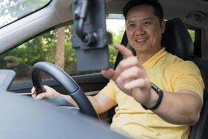 Portrait of a man using his cell phone while driving. Businessman looking at smartphone photo
