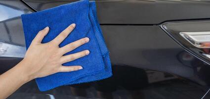 I made it perfectly clean. A woman at a car wash does a full dry-cleaning of all parts of a car using special chemistry photo