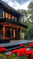 Modern black wooden house with large terrace and garden in bloom photo
