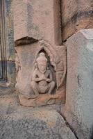 Hermit Carved laterite pillar in Prasat Muang Tam, Ancient Historical castle in Thailand. photo
