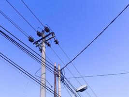 Power electric pole with line wire for residential buildings with blue sky background photo