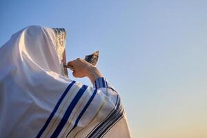 Jewish man blowing the Shofar rams horn on Rosh Hashanah and Yom Kippur day. photo