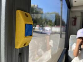 Close up photo of bus stop button with faded letters in city bus