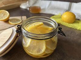 Food useful for immunity. Honey lemons in a glass jar for refreshing lemon tea. Lemon in honey syrup. Healthy food photo