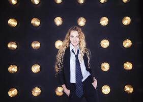 Woman wearing classical suit over golden shining background photo