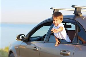 Portrait of a smiling little boy at beach in the car photo