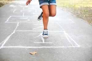 Kid playing hopscotch on playground outdoors photo