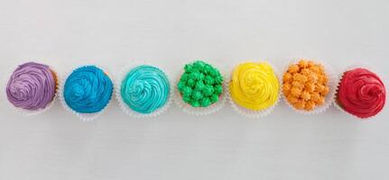 Rainbow cupcakes on the white background with copy space photo