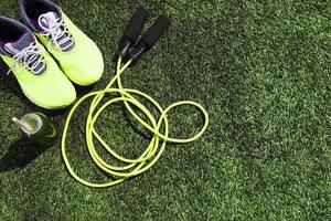Running shoes, jump rope and drink bottle with green juice photo