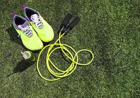 Running shoes, jump rope and drink bottle with green juice photo