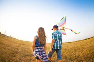 Little children playing with flying kite on the summer field photo