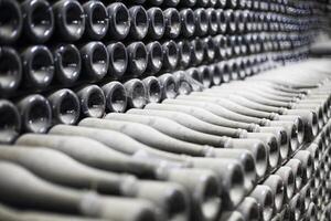 Stacked up dusty champagne bottles in the cellar photo