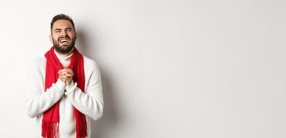 Christmas holidays and New Year concept. Man in need begging for help, pleading and looking miserable, apologizing for something, standing over white background photo