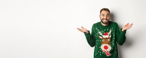 New Year, holidays and celebration. Confused bearded man shrugging, dont know anything, standing clueless against white background photo