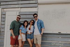 Group of joyful friends bonding and smiling while spending summer day outdoors together photo