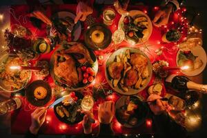 Top view of people enjoying variety of Christmas dishes while having holiday dinner at the decorated table photo