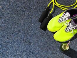 Running shoes, jump rope and drink bottle with green juice photo