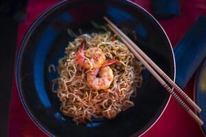 Chinese noodles with shrimps on the table photo