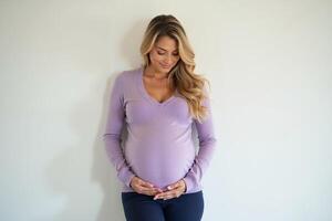 photo of pregnant woman standing against white wall background,